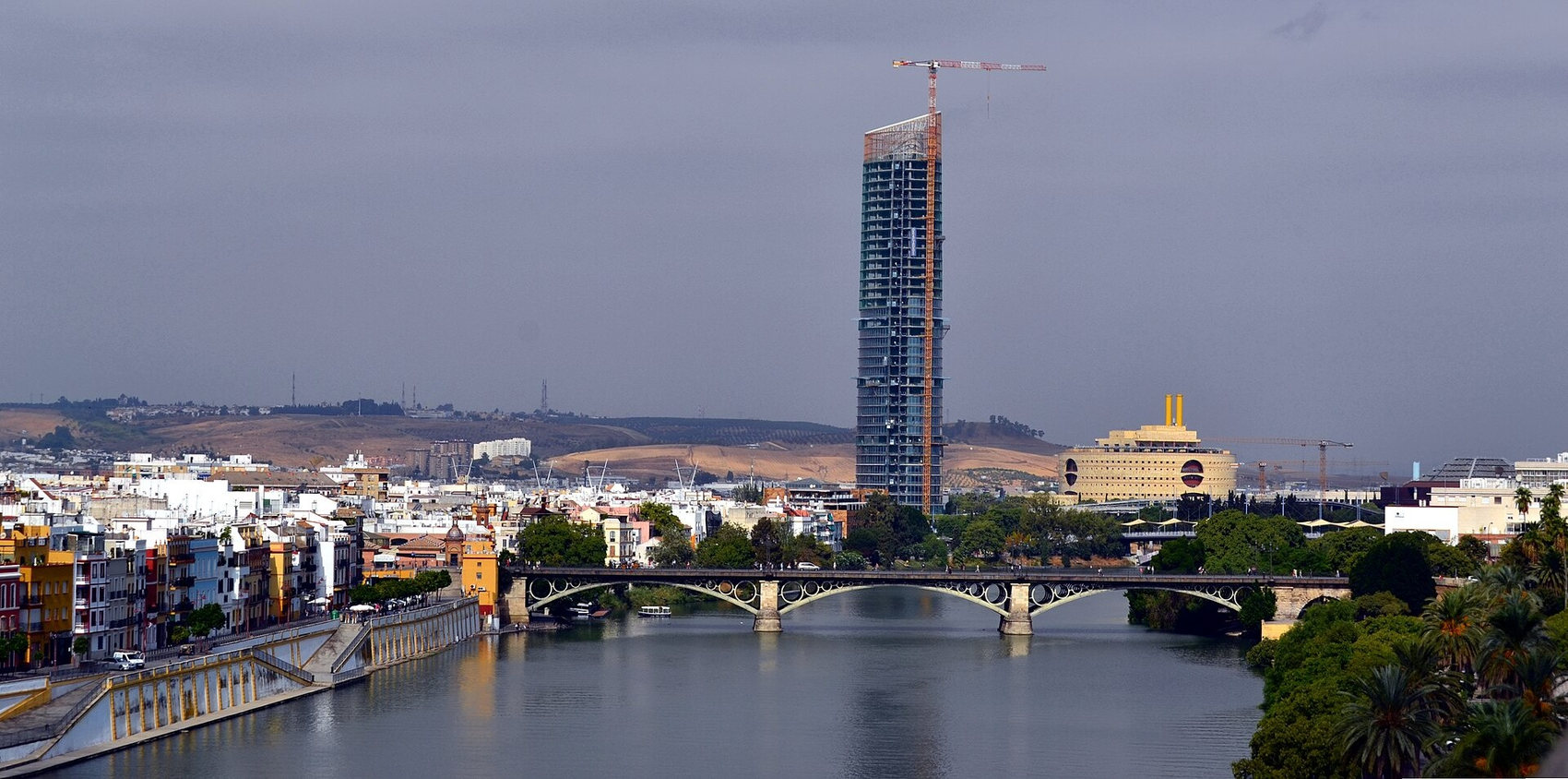 Imagen 1. El Guadalquivir y el puente de Triana desde la Torre del Oro. Al fondo, por encima del caserío de Triana, se recorta el escarpe de la cornisa del Aljarafe.